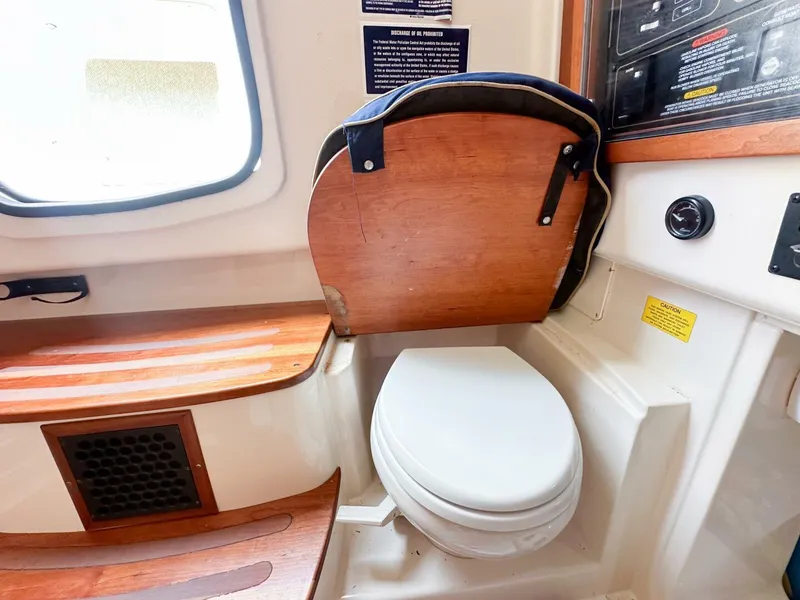 Slide: The Image of Grady-White 366 Canyon 2011 boat interior with toilet and wooden seat. - 10