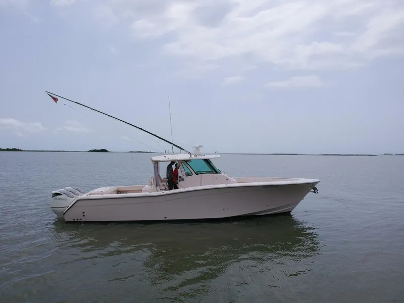 Slide: The Image of 2011 Grady-White 366 Canyon boat with 2020 Suzuki engines on calm water. - 22