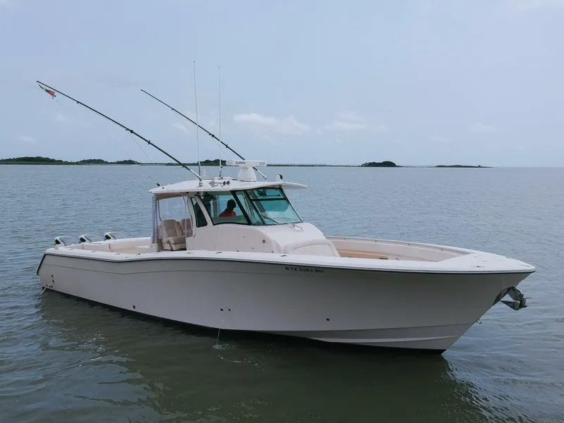 Slide: The Image of 2011 Grady-White 366 Canyon boat with 2020 Suzuki engines on calm water. - 23