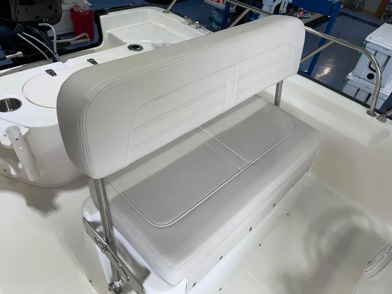 Slide: The Image of 2024 Boston Whaler 150 Montauk boat interior with white cushioned seating. - 10