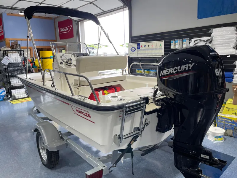Slide: The Image of 2024 Boston Whaler 150 Montauk boat with Mercury 60 engine in showroom. - 11