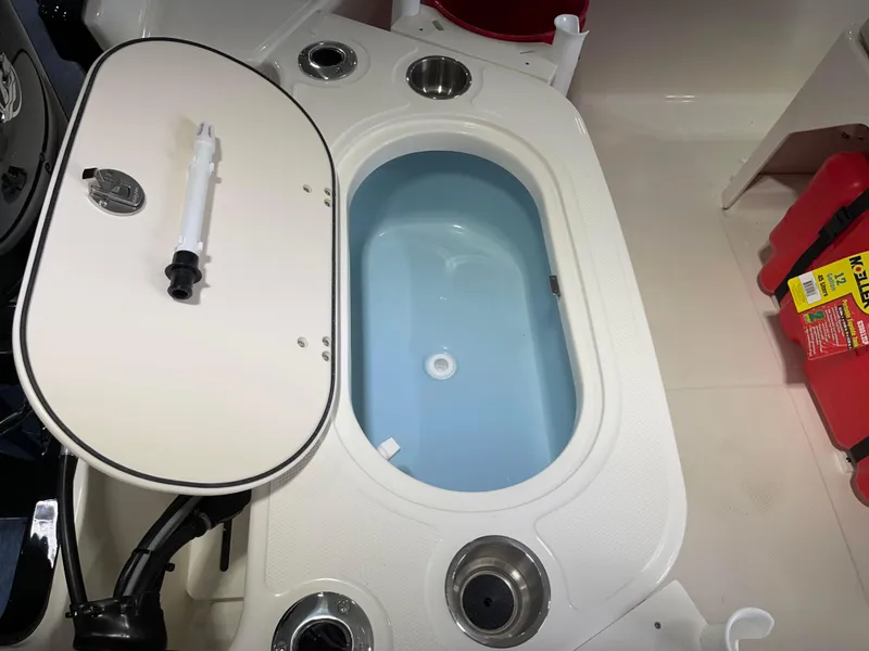 Slide: The Image of 2024 Boston Whaler 150 Montauk livewell with open lid and fishing rod holder. - 12