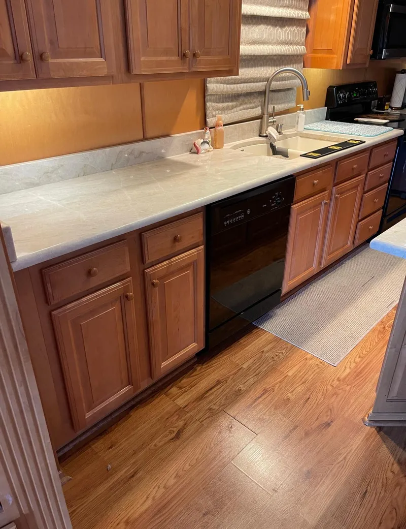 Slide: The Image of Kitchen area of a 2003 Sharpe 75' Houseboat with wooden cabinets and marble countertops. - 13