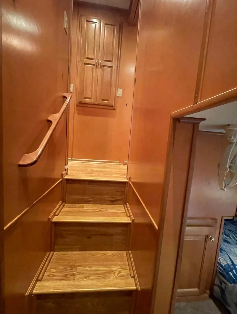 Slide: The Image of Staircase inside 2003 Sharpe 75' Houseboat with wooden steps and cabinets. - 19