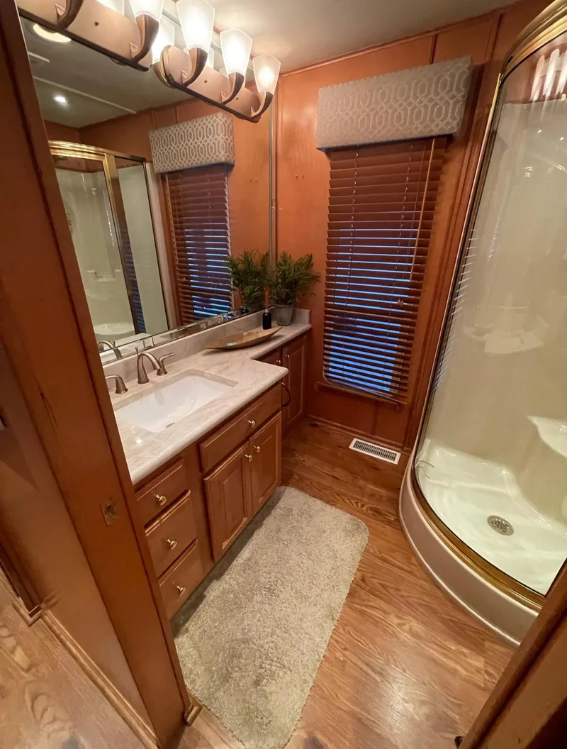 Slide: The Image of 2003 Sharpe 75' Houseboat bathroom with wooden cabinets, sink, and shower. - 20