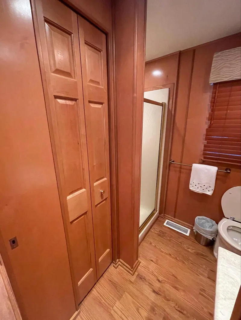 Slide: The Image of Bathroom in a 2003 Sharpe 75' Houseboat with wooden cabinets and flooring. - 30