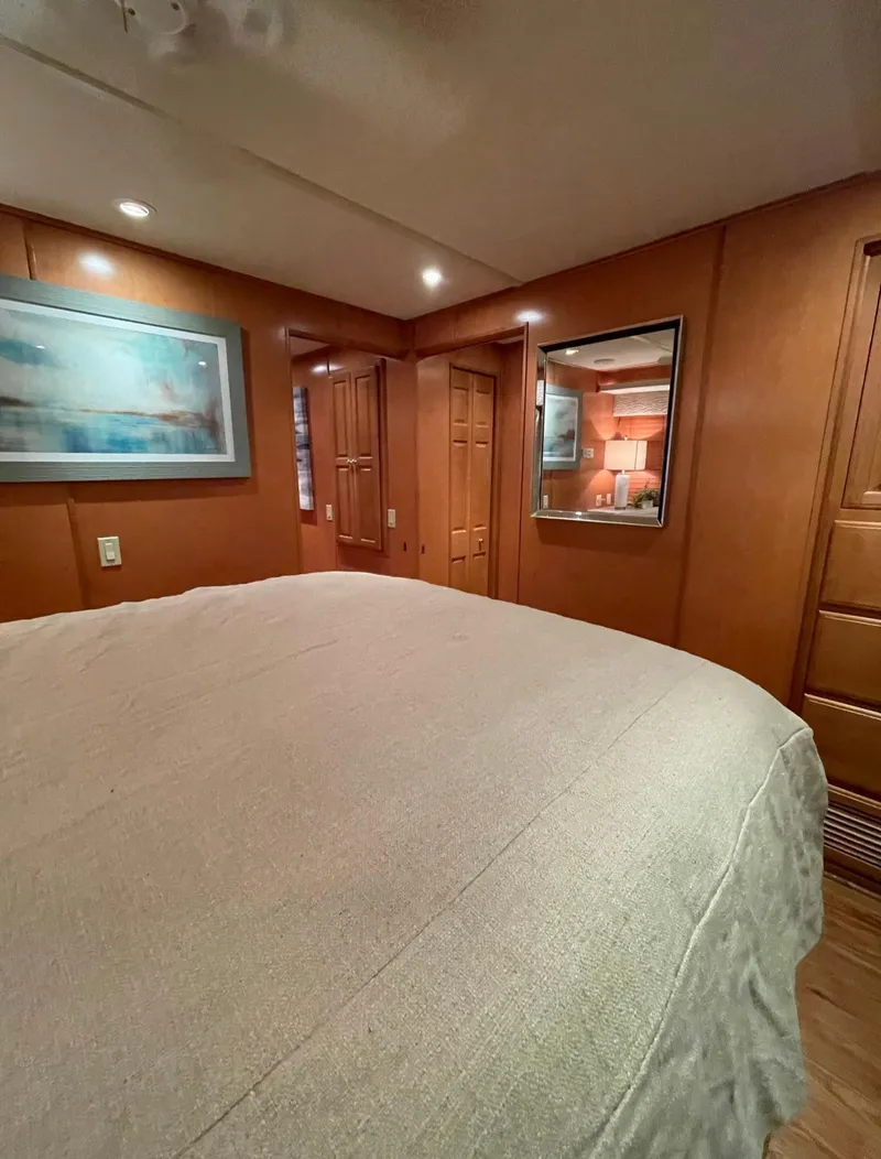 Slide: The Image of Luxurious bedroom interior of a 2003 Sharpe 75' Houseboat with wood paneling and cozy lighting. - 31