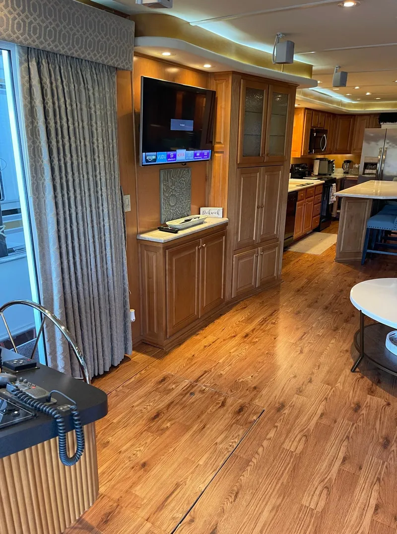 Slide: The Image of 2003 Sharpe 75' Houseboat interior with wooden flooring, modern kitchen, and entertainment area. - 4