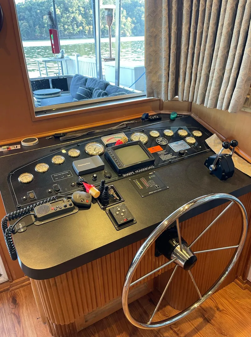 Slide: The Image of 2003 Sharpe 75' Houseboat helm with control panel and steering wheel. - 8