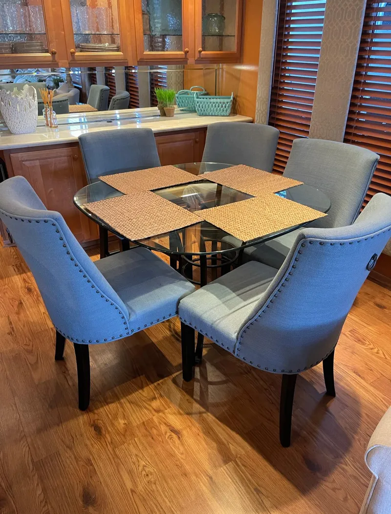 Slide: The Image of Dining area in a 2003 Sharpe 75' Houseboat with a glass table and six upholstered chairs. - 9