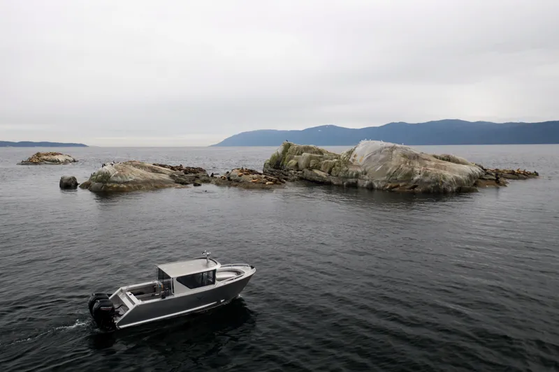 Slide: The Image of Jasper Marine Defender 22 boat cruising near rocky islands, 2025 model. - 41