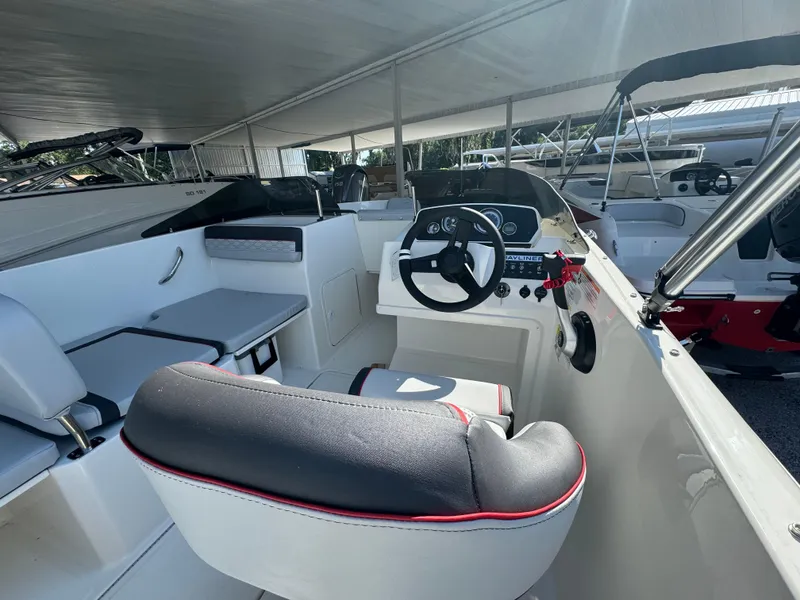 Slide: The Image of 2024 Bayliner Element M19 boat interior with steering console and seating. - 5