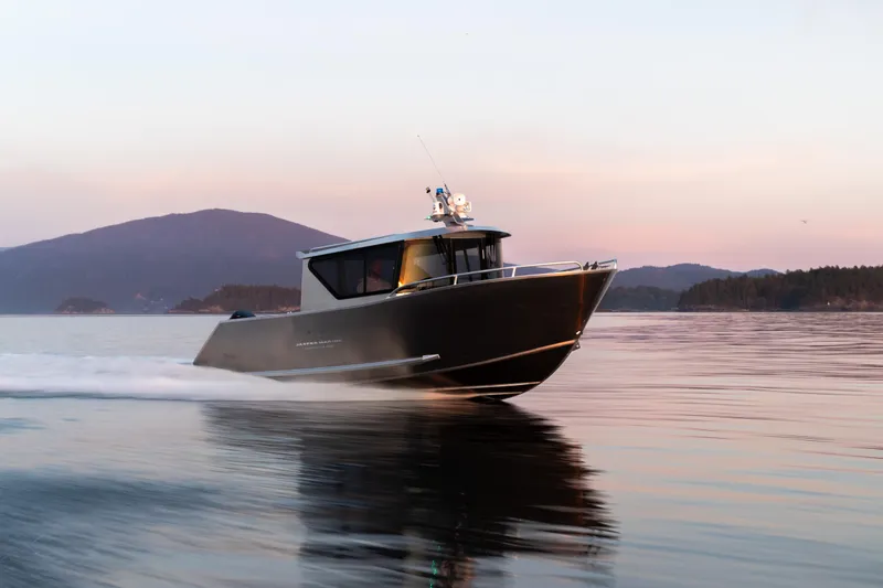 Slide: The Image of 2025 Jasper Marine Defender 22 boat cruising on calm water at sunset. - 16