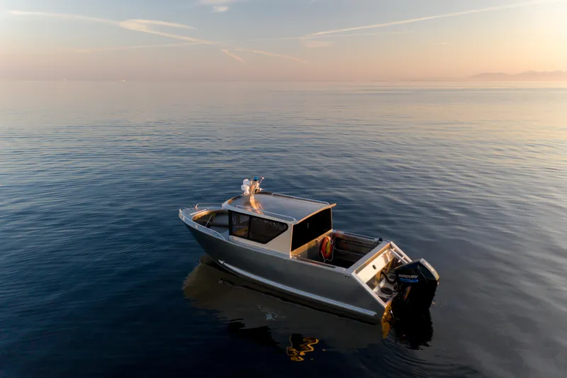 Slide: The Image of 2025 Jasper Marine Defender 22 boat on calm water at sunset. - 37