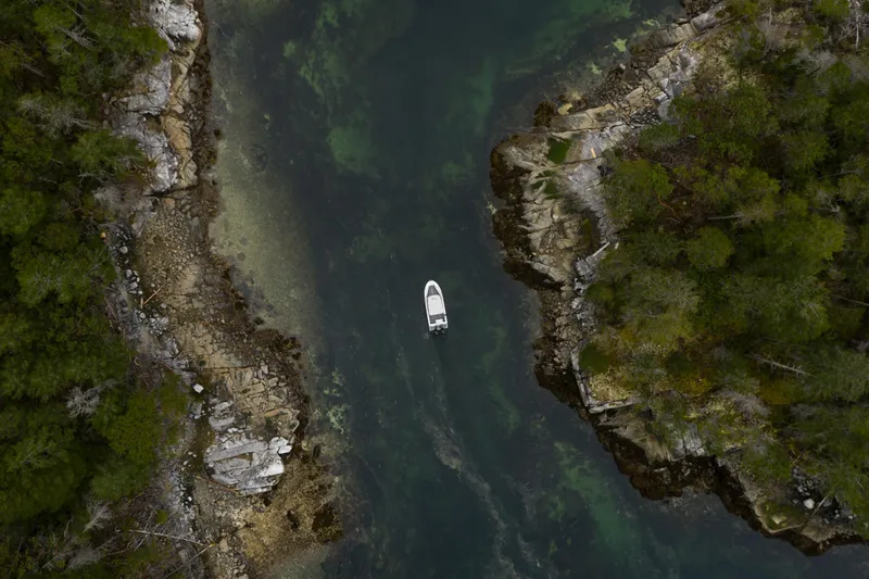 Slide: The Image of Aerial view of Jasper Marine Defender 22 boat navigating through a narrow, rocky waterway. - 38