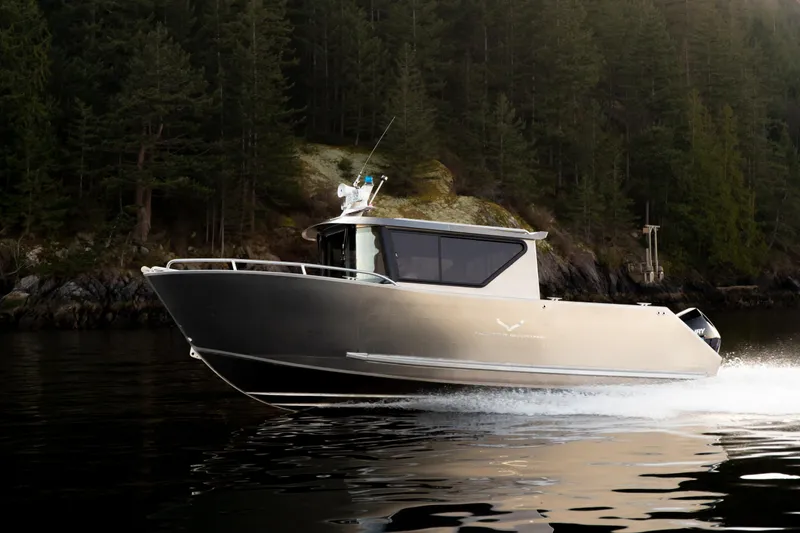 Slide: The Image of 2025 Jasper Marine Defender 22 boat cruising on a serene lake with forested background. - 10