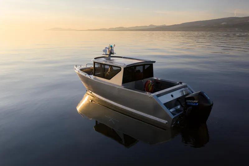 Slide: The Image of 2025 Jasper Marine Defender 22 boat on calm water at sunset. - 4