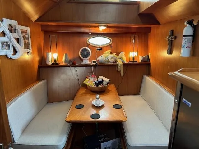 Slide: The Image of 1989 Jefferson Motoryacht interior dining area with wooden table, cushioned seating, and nautical decor. - 12