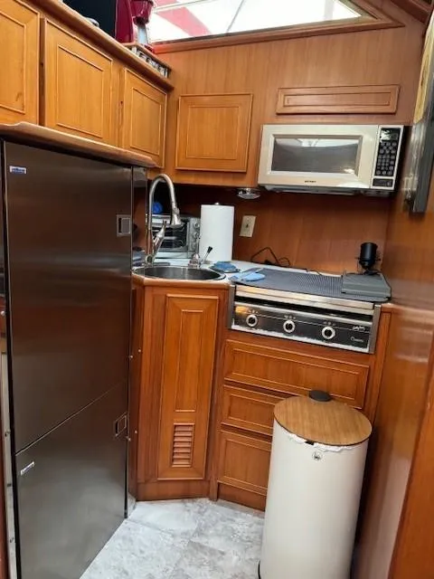 Slide: The Image of 1989 Jefferson Motoryacht kitchen with stainless steel appliances and wooden cabinetry. - 14