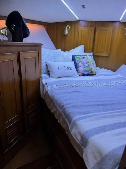 Slide: The Image of Cozy bedroom in a 1989 Jefferson Motoryacht with wooden cabinetry and decorative pillows. - 15