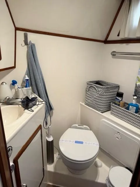 Slide: The Image of 1989 Jefferson Motoryacht bathroom with sink, toilet, and storage baskets. - 17
