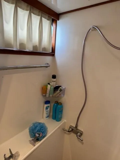 Slide: The Image of Shower area in a 1989 Jefferson Motoryacht with toiletries and a handheld showerhead. - 18