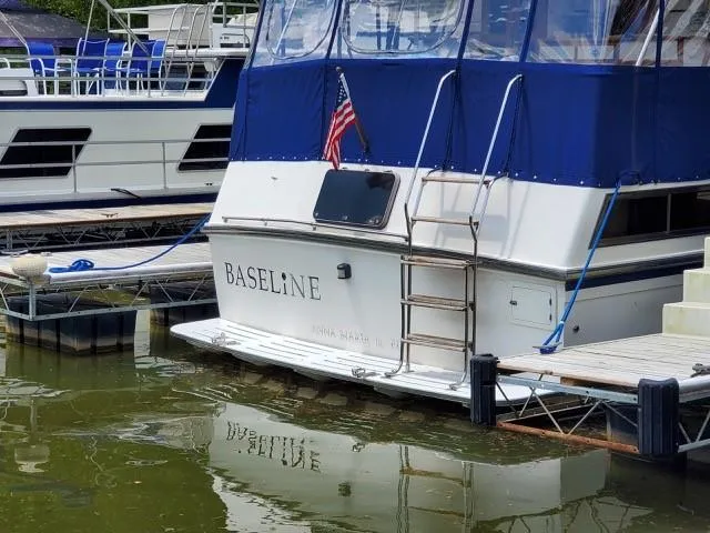 Slide: The Image of 1989 Jefferson Motoryacht Baseline docked with blue canopy and American flag. - 4
