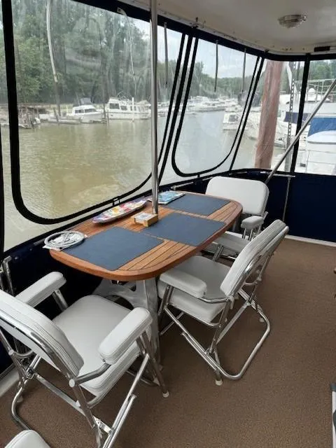 Slide: The Image of 1989 Jefferson Motoryacht interior dining area with table and chairs, docked at marina. - 5