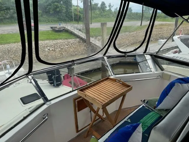 Slide: The Image of 1989 Jefferson Motoryacht interior with dock view, wooden table, and cushioned seating. - 8
