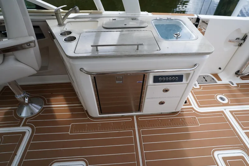 Slide: The Image of Boston Whaler 320 Vantage 2016 boat galley with sink, stove, and refrigerator. - 12