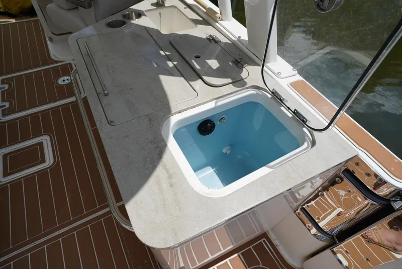 Slide: The Image of Boston Whaler 320 Vantage 2016 boat deck with sink and storage compartments. - 13