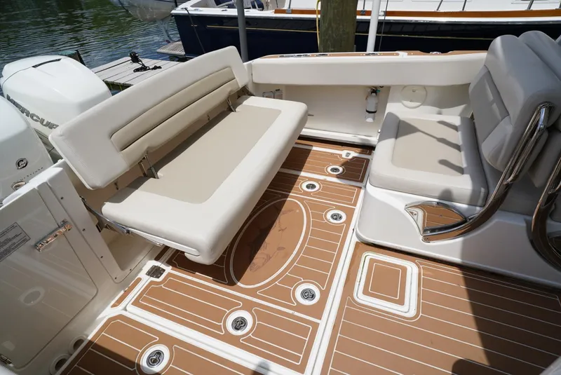 Slide: The Image of 2016 Boston Whaler 320 Vantage boat interior with cushioned seating and teak flooring. - 16