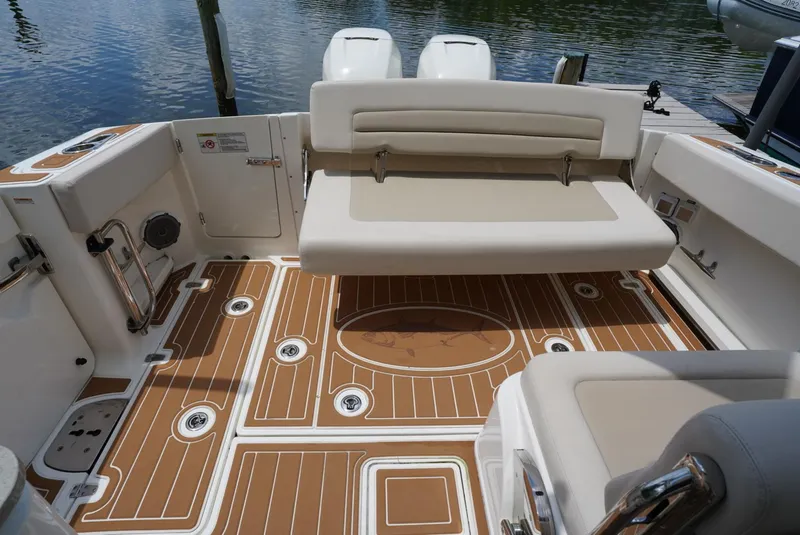 Slide: The Image of 2016 Boston Whaler 320 Vantage boat interior with cushioned seating and teak flooring. - 18