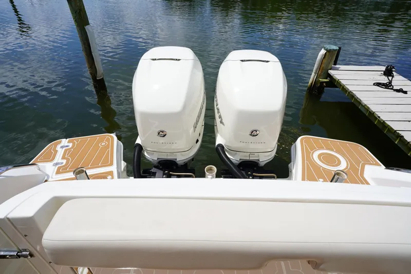 Slide: The Image of Twin outboard engines on a 2016 Boston Whaler 320 Vantage docked by the water. - 20