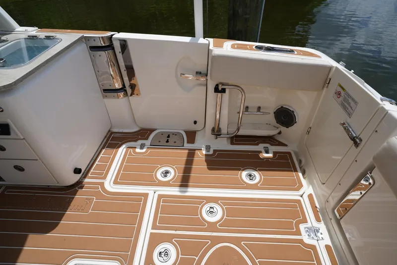 Slide: The Image of 2016 Boston Whaler 320 Vantage boat deck with teak flooring and storage compartments. - 22