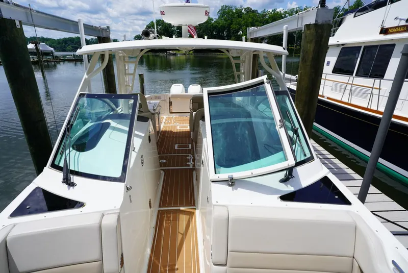 Slide: The Image of 2016 Boston Whaler 320 Vantage docked, showcasing open cockpit and seating area. - 4