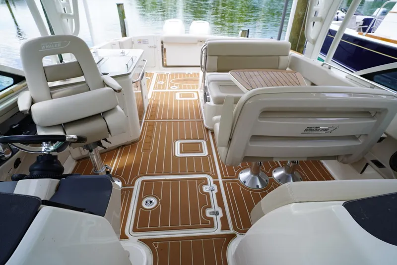 Slide: The Image of 2016 Boston Whaler 320 Vantage boat interior with teak flooring and cushioned seating. - 5