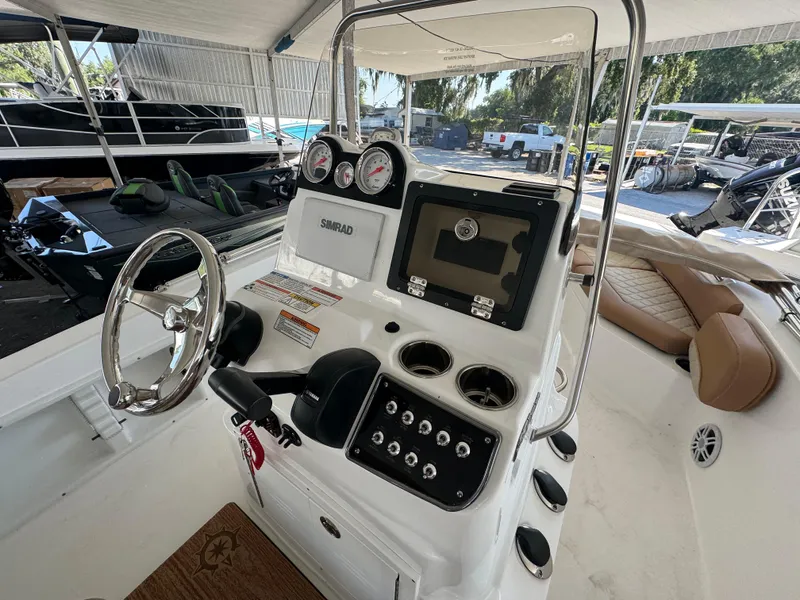 Slide: The Image of 2024 NauticStar 191 Hybrid boat dashboard with steering wheel and navigation controls. - 2