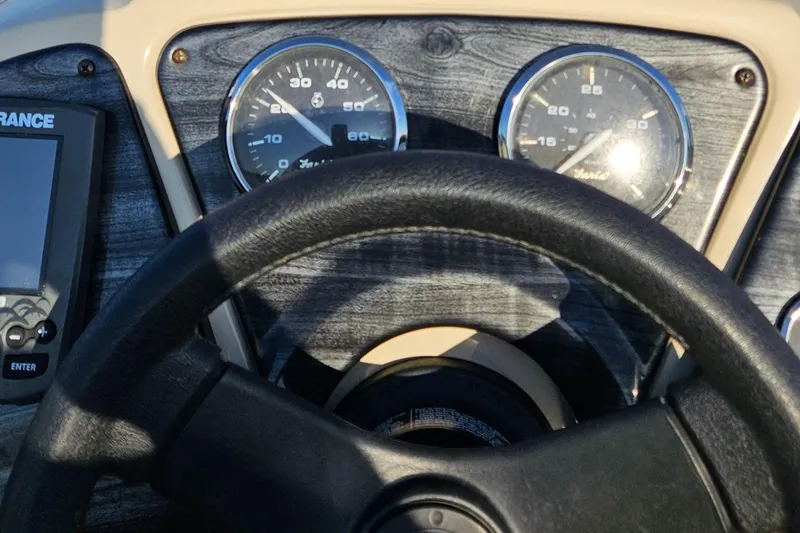 Slide: The Image of 2018 Sweetwater Sunrise 226 C boat dashboard with steering wheel and gauges. - 18