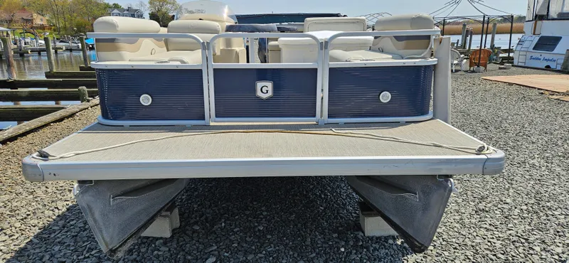 Slide: The Image of 2018 Sweetwater Sunrise 226 C pontoon boat docked on gravel. - 2