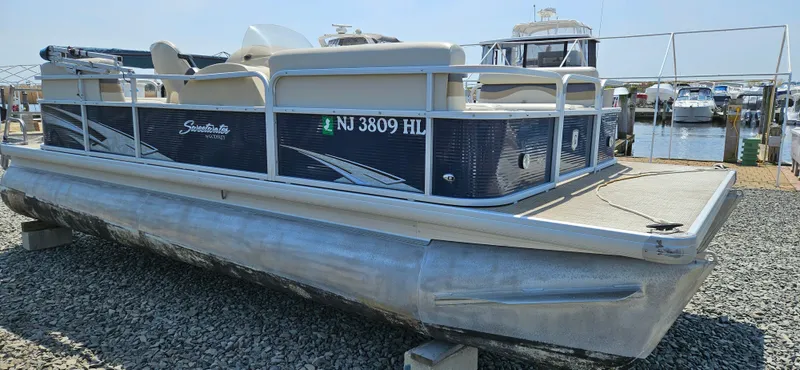 Slide: The Image of 2018 Sweetwater Sunrise 226 C pontoon boat docked on gravel. - 4