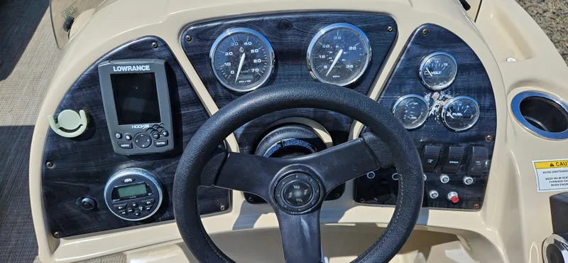 Slide: The Image of 2018 Sweetwater Sunrise 226 C boat dashboard with steering wheel, gauges, and Lowrance electronics. - 8