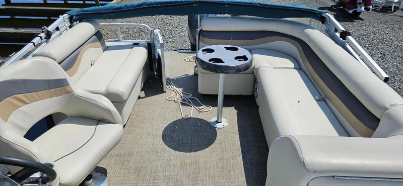 Slide: The Image of 2018 Sweetwater Sunrise 226 C pontoon boat with beige seating and a central table. - 9