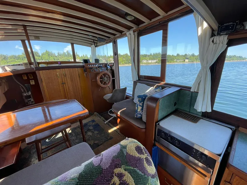 Slide: The Image of Interior of a 1931 Jensen Cruiser boat with wooden furnishings and scenic lake view. - 10