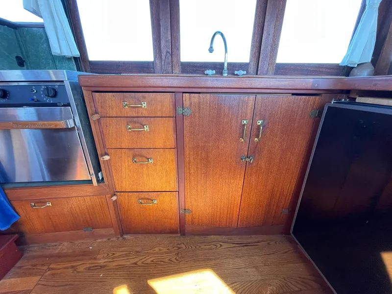 Slide: The Image of Wooden kitchen interior of a 1931 Jensen Cruiser with cabinets and a sink. - 12