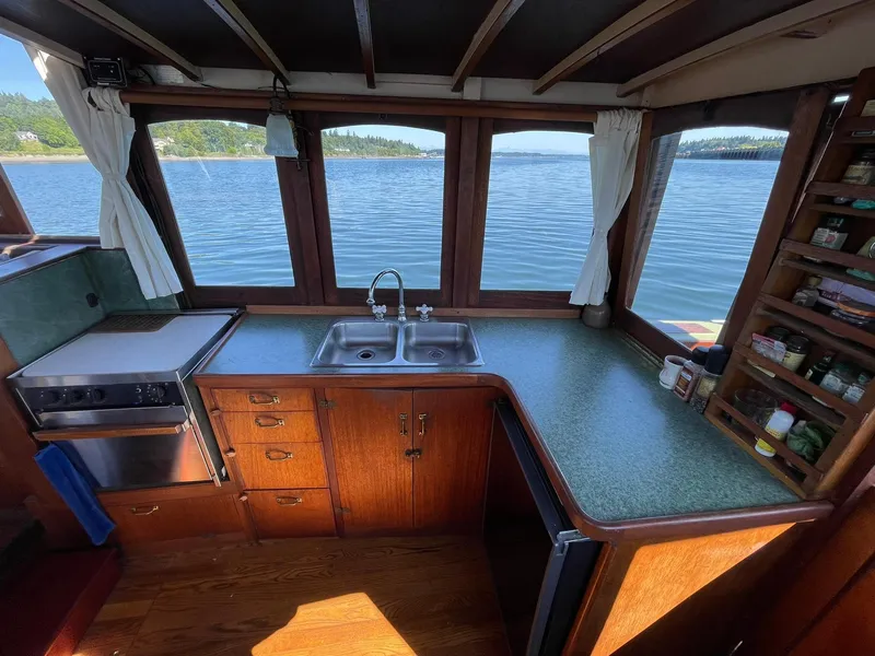 Slide: The Image of Interior of a 1931 Jensen Cruiser with a kitchen overlooking a scenic lake view. - 16