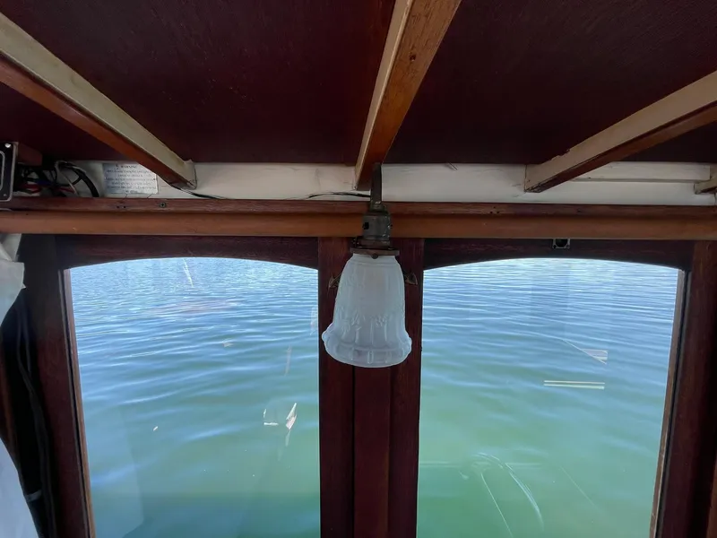 Slide: The Image of Interior view of a 1931 Jensen Cruiser with a vintage light fixture and water outside. - 17