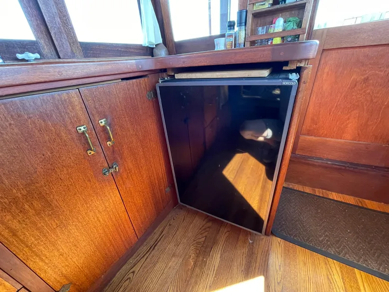 Slide: The Image of 1931 Jensen Cruiser interior with wooden cabinetry and a compact refrigerator. - 18