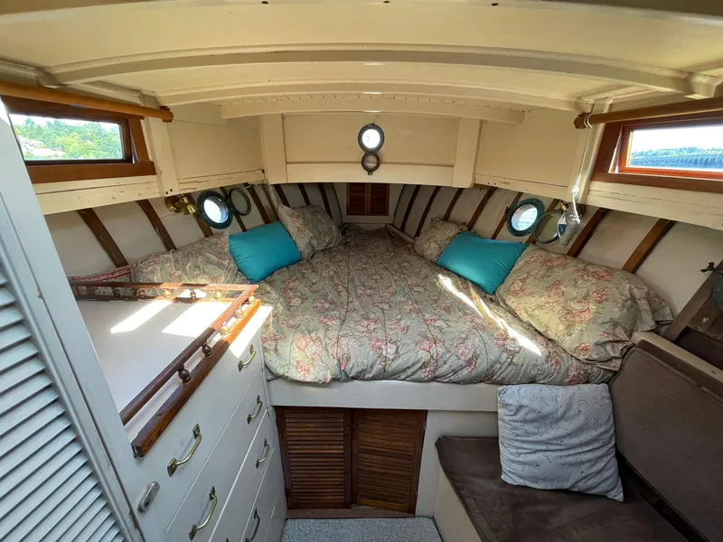 Slide: The Image of Cozy cabin interior of a 1931 Jensen Cruiser with floral bedding and porthole windows. - 21