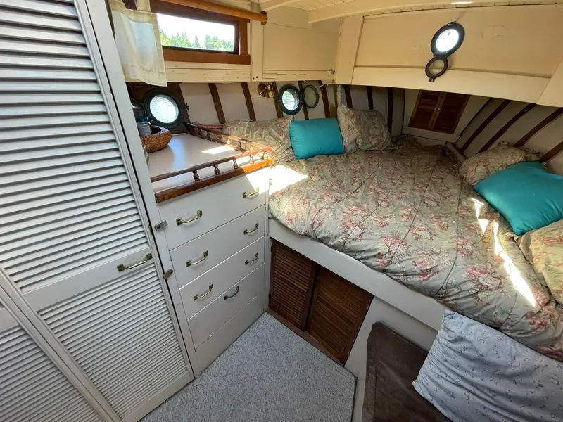 Slide: The Image of Cozy cabin interior of a 1931 Jensen Cruiser with floral bedding and porthole windows. - 22